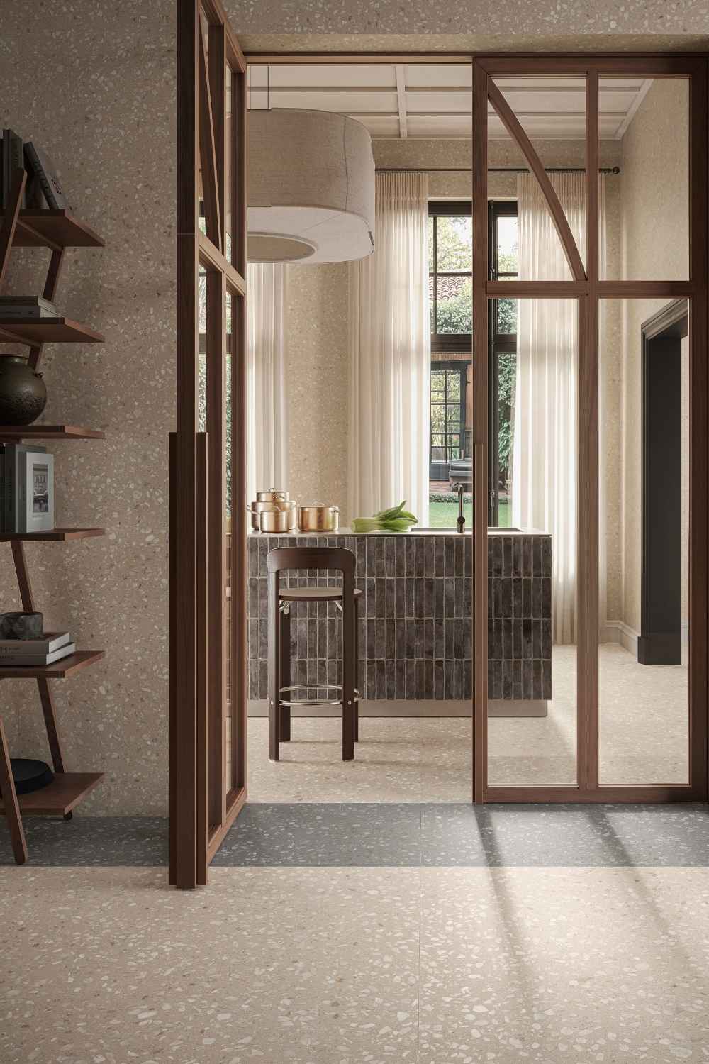 Wohnraum mit Sant Agostino Glow Sand matt als Bodenfliese in heller Terrazzo-Optik, kombiniert mit warmen Holzrahmen und elegantem Küchendesign