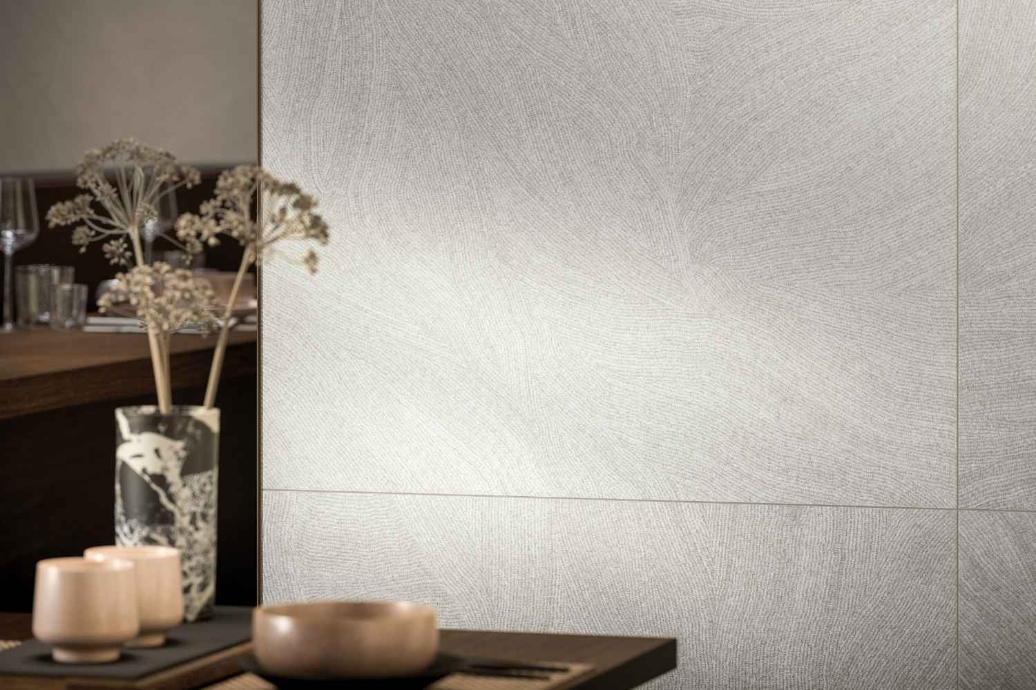 Refin Ink Pure als Wandfliese in heller Weiß-, Creme- und Greige-Optik mit feiner textilartiger Struktur und sanft geschwungenem Linienbild in einem modernen Wohnambiente