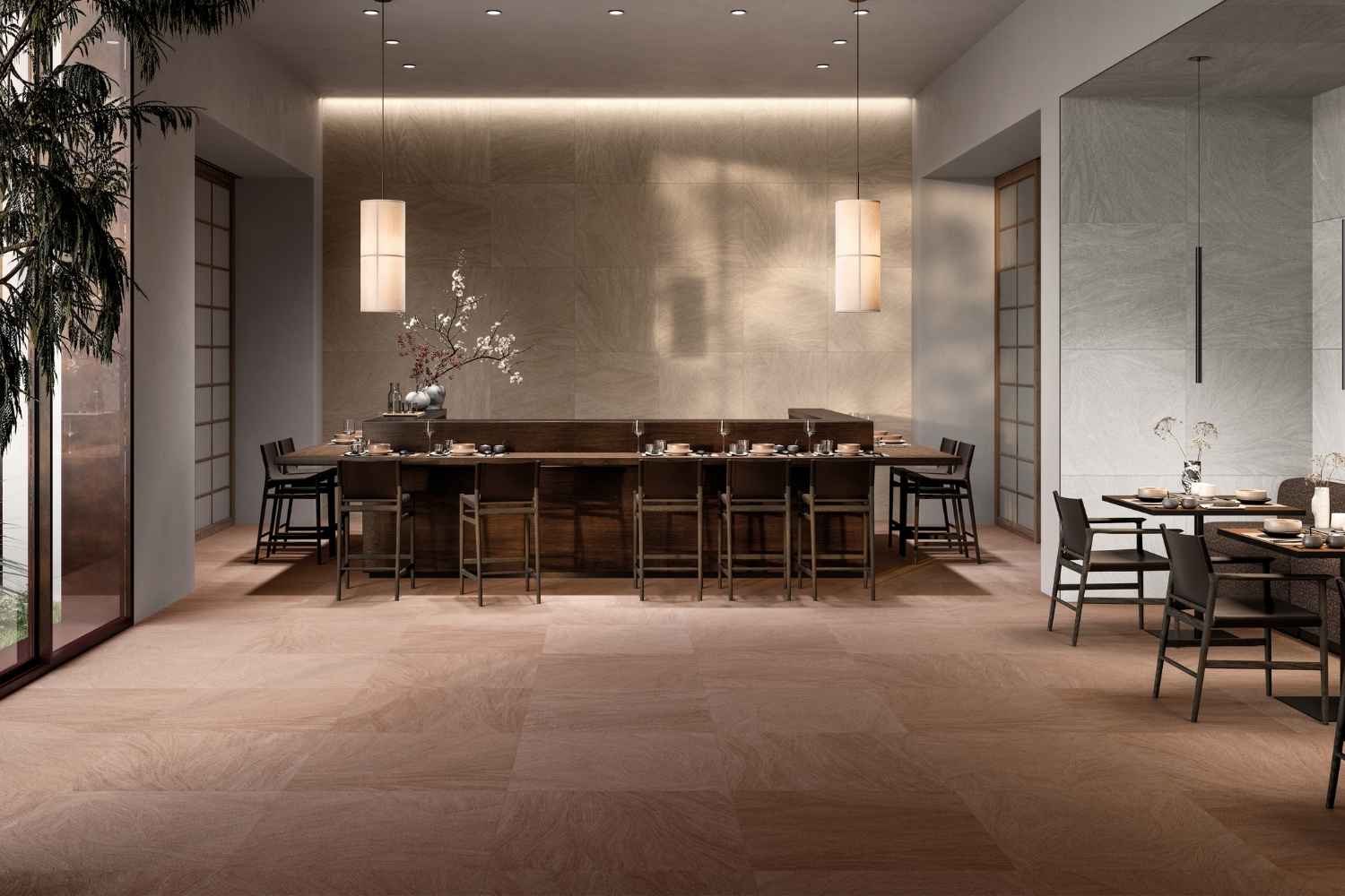 Refin Ink Earthy als Boden- und Wandfliese in warmer erdiger Braun- und Taupe-Farbgebung mit feiner textilartiger Struktur und moderner Steinoptik, verlegt in einem stilvollen Restaurantbereich