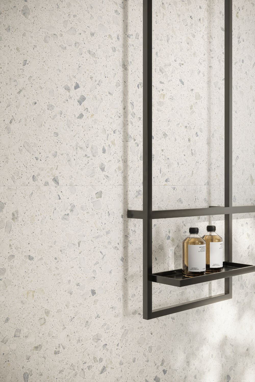 Detailaufnahme der Sant Agostino Glow Light als helle Wandfliese in feiner Terrazzo-Optik mit dezenten Steinfragmenten in Weiß, Grau und sanften Naturtönen