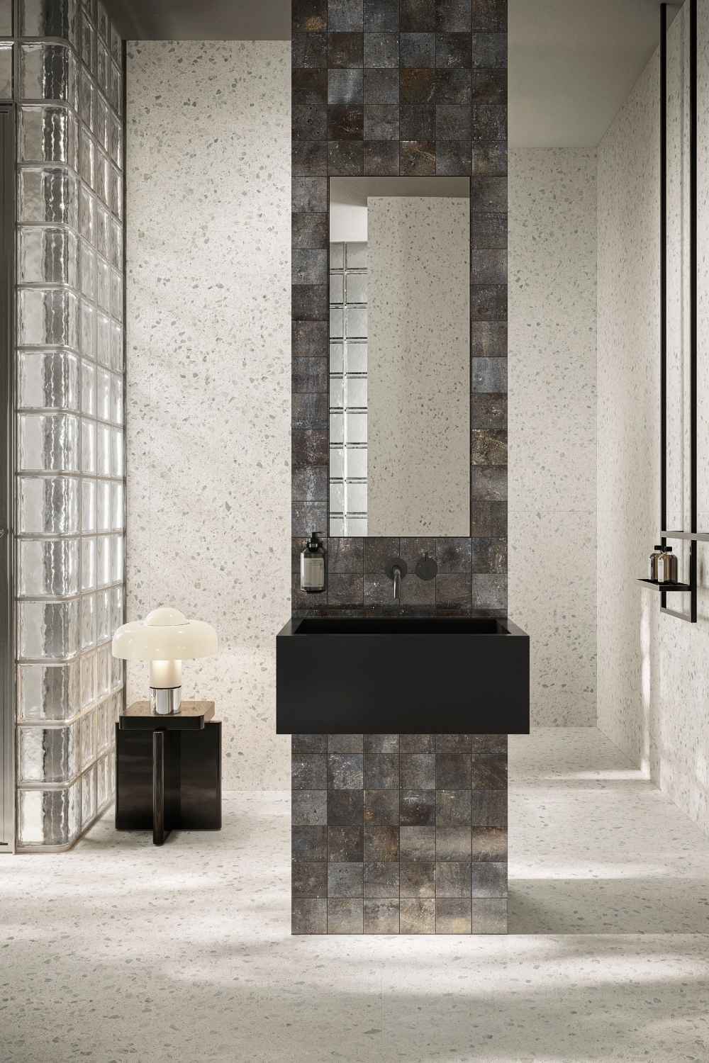 Modernes Badezimmer mit Sant Agostino Glow Light als helle Boden- und Wandfliese in feiner Terrazzo-Optik, kombiniert mit schwarzem Waschtisch und dunkler Mosaik-Akzentwand
