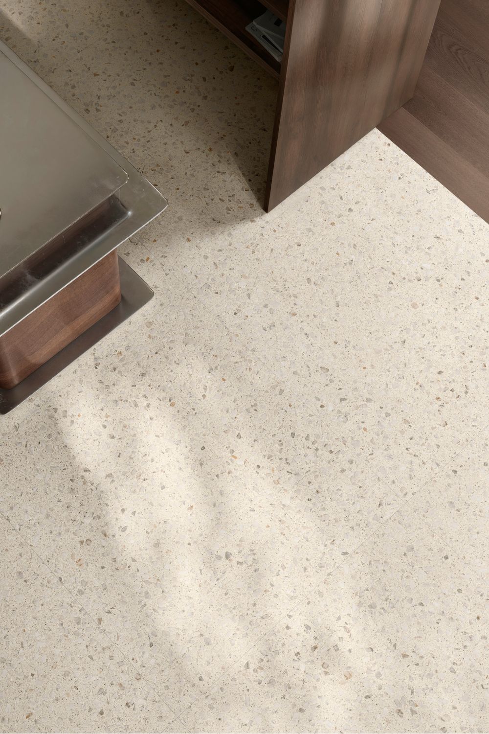 Detailaufnahme der Sant Agostino Glow Ivory mit hellem Elfenbeinton und feiner Terrazzo-Optik aus dezenten grauen, beigen und cremefarbenen Steinfragmenten