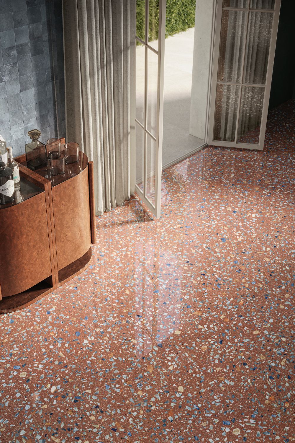 Detailaufnahme der Sant Agostino Glow Plus Sunset glänzend poliert mit warmer Terrakotta-Terrazzo-Optik und farbigen Steinfragmenten in Blau, Grau, Beige und Weiß