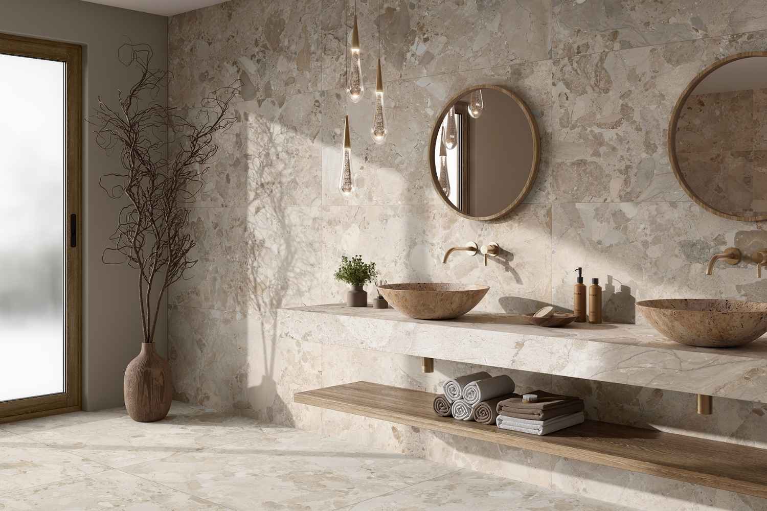 Terrazzo-Fliese beige matt Dozza Stone Cream im Badezimmer mit Waschtisch, runden Spiegeln und moderner Armatur
